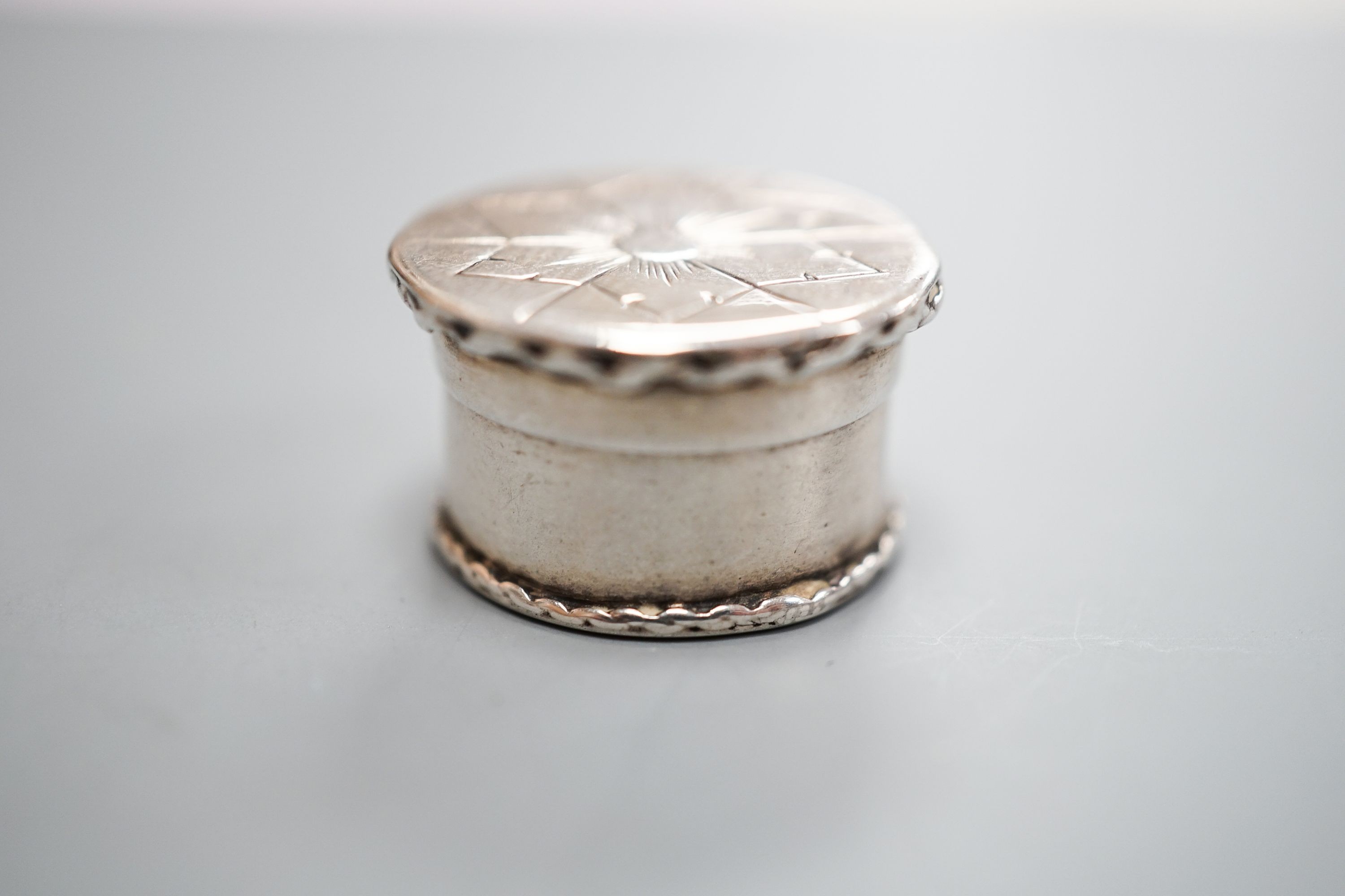 A mid 18th century German? small pill box, with engraved flower head decoration, 19mm.